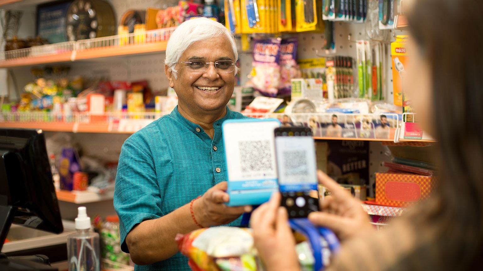 Shopkeeper displaying a QR code